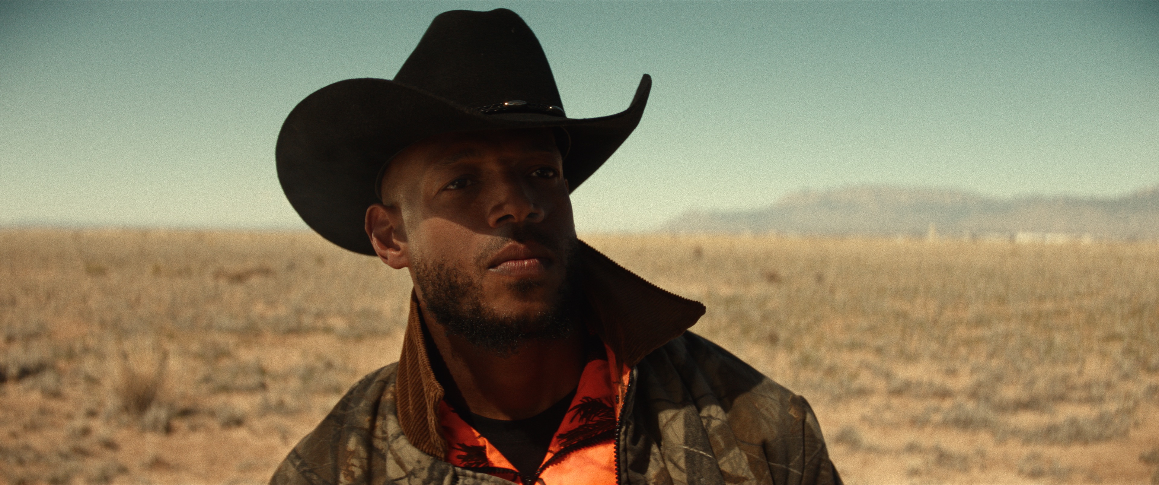 Actor Marlon Wayans in character wearing a cowboy hat in the desert.