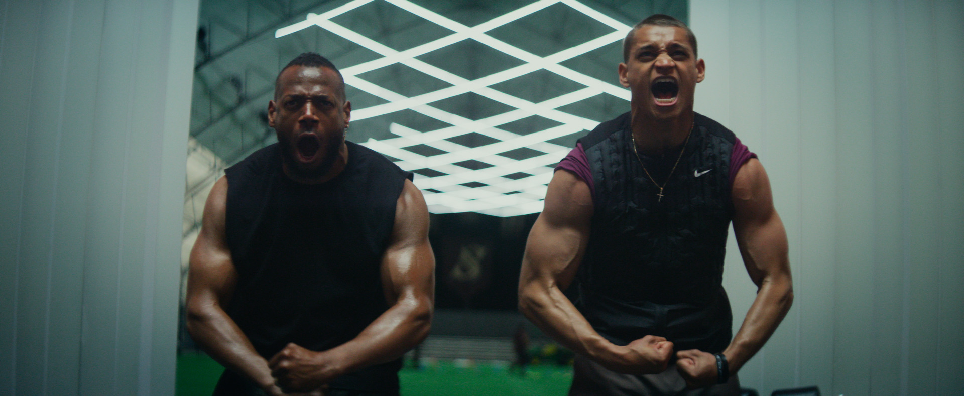 Actors Marlon Wayans and Tyriq Withers in character showing off their biceps and yelling.