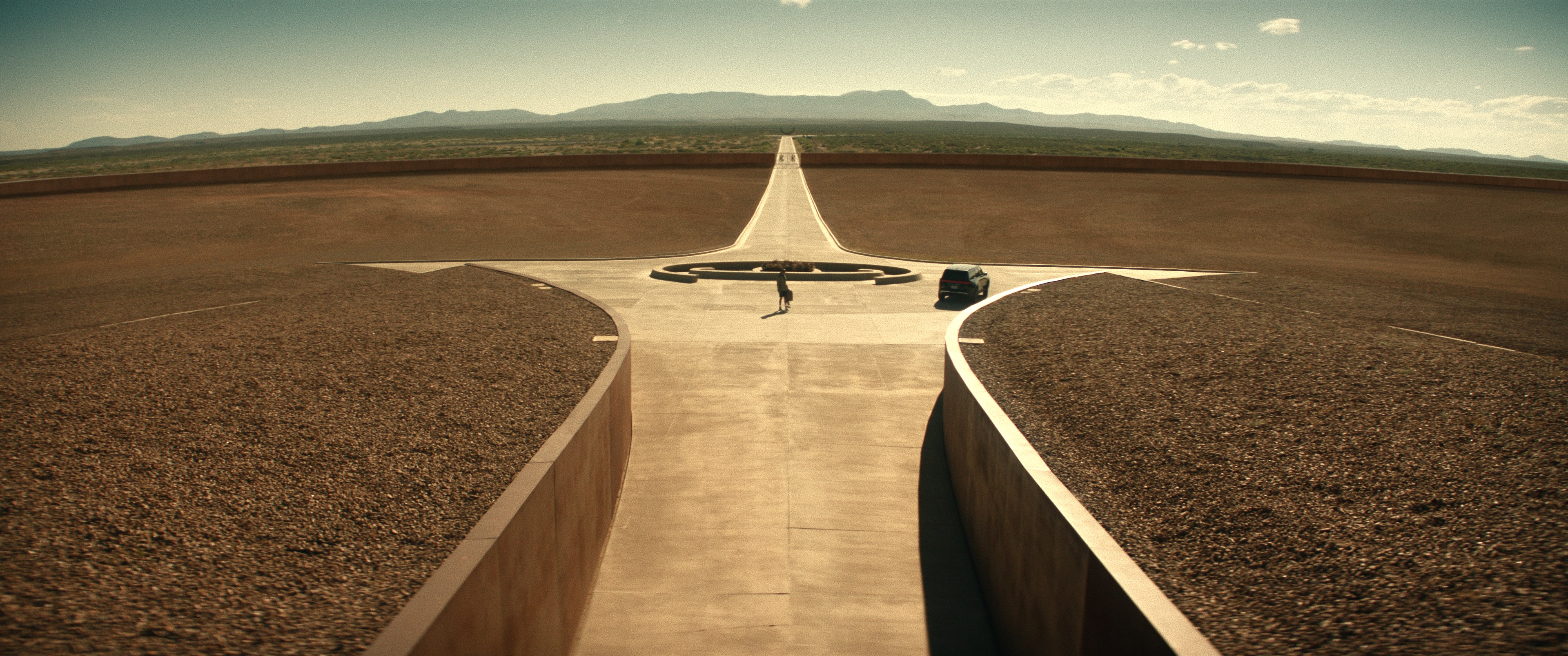 A surreal desert landscape with a sprawling geometric helipad.