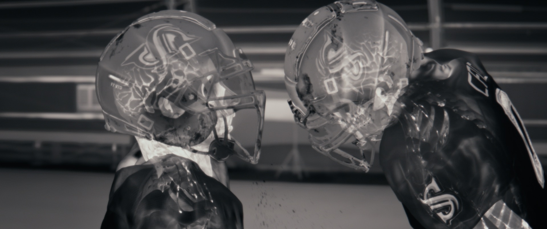 Thermal camera X-ray like black and white image of two football players going head to head.