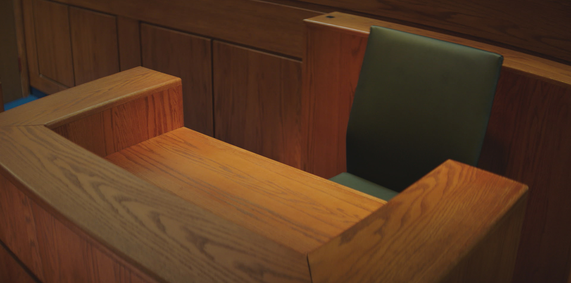 An empty witness chair in a courtroom in the 2019 documentary series LORENA.