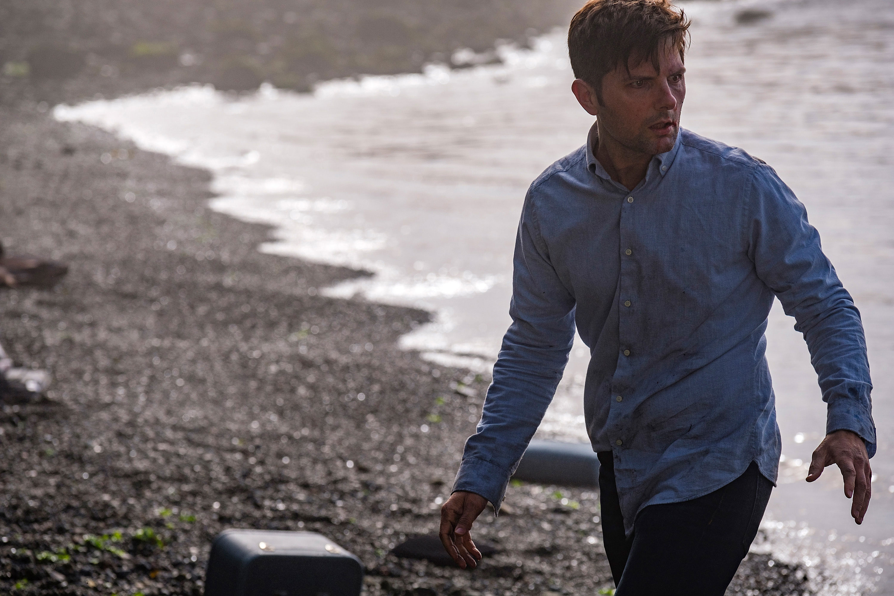 Adam Scott in the 2019 television series THE TWILIGHT ZONE walking on a beach.