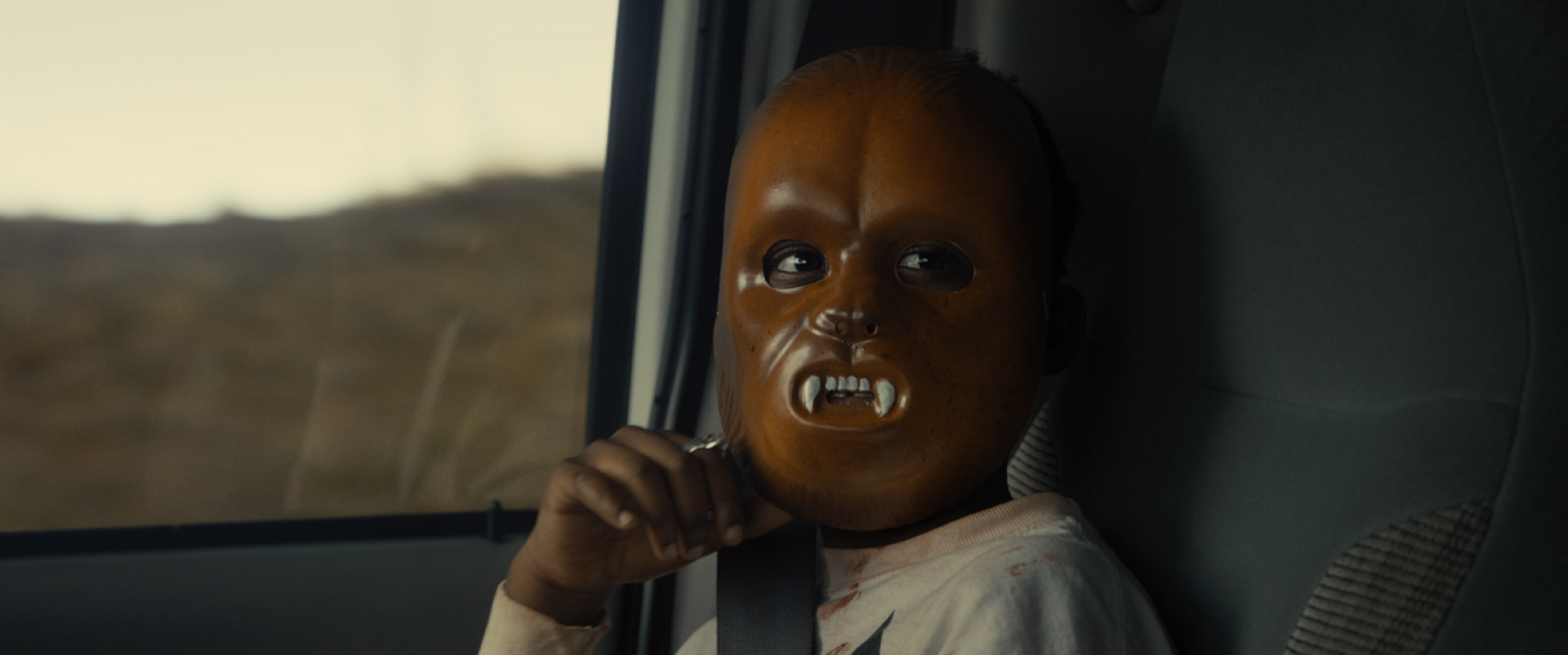 Evan Alex in the 2019 film US sitting in car wearing werewolf mask.
