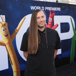 Ian Cooper standing on the red carpet with a nope banner in the background.