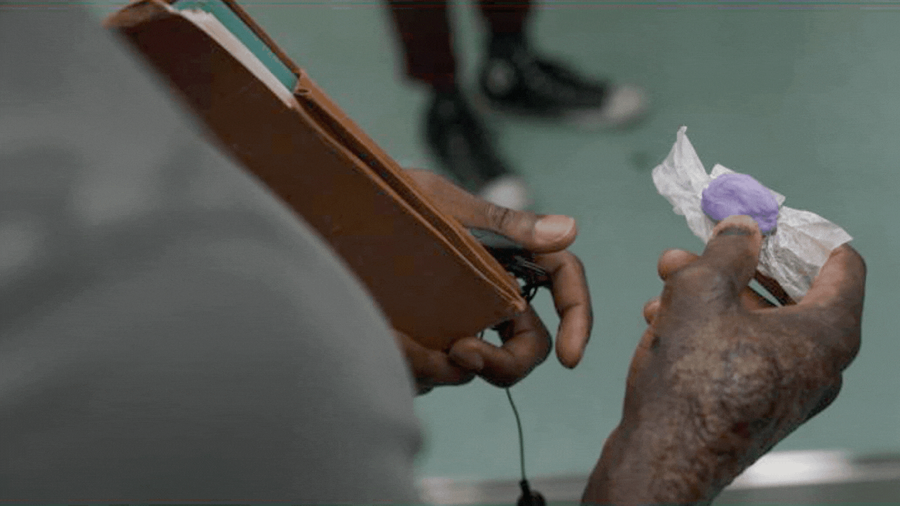 Gif of the before and after of Candyman's hand holding up a piece of Candy. Each photo shows the progression of the special effects makeup