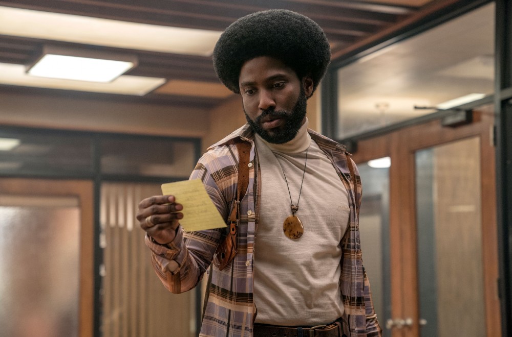 John David Washington in the 2018 film BLACKKKLANSMAN looking at a piece of paper.